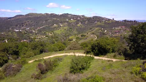 Aerial-View-of-Malibu-houses-and-Santa-Monica-Mountains-on-a-warm-sunny-day-4K