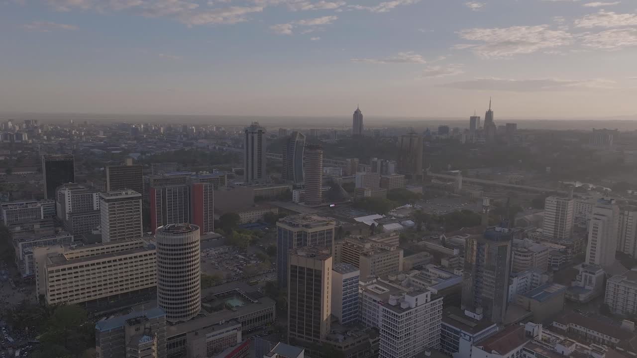 Drone shot of Warm golden hour light reflects off modern office towers in Nairobi city into the horizon, highlighting Nairobi’s rapid urban development