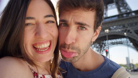 4k video footage of a young couple taking selfies in front of the eiffel tower in paris, france