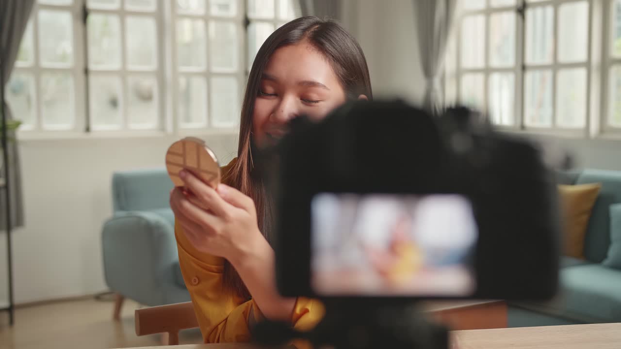 Beauty Blogger Woman Filming Daily Make-Up Routine Tutorial At Camera On Tripod. Influencer Girl Live Streaming Cosmetics Product Review In Home Studio. Vlogger Female Applies Skin Powder With Brush