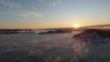 golden hour sunset light over port near bjorvika, oslo with fog floating above water