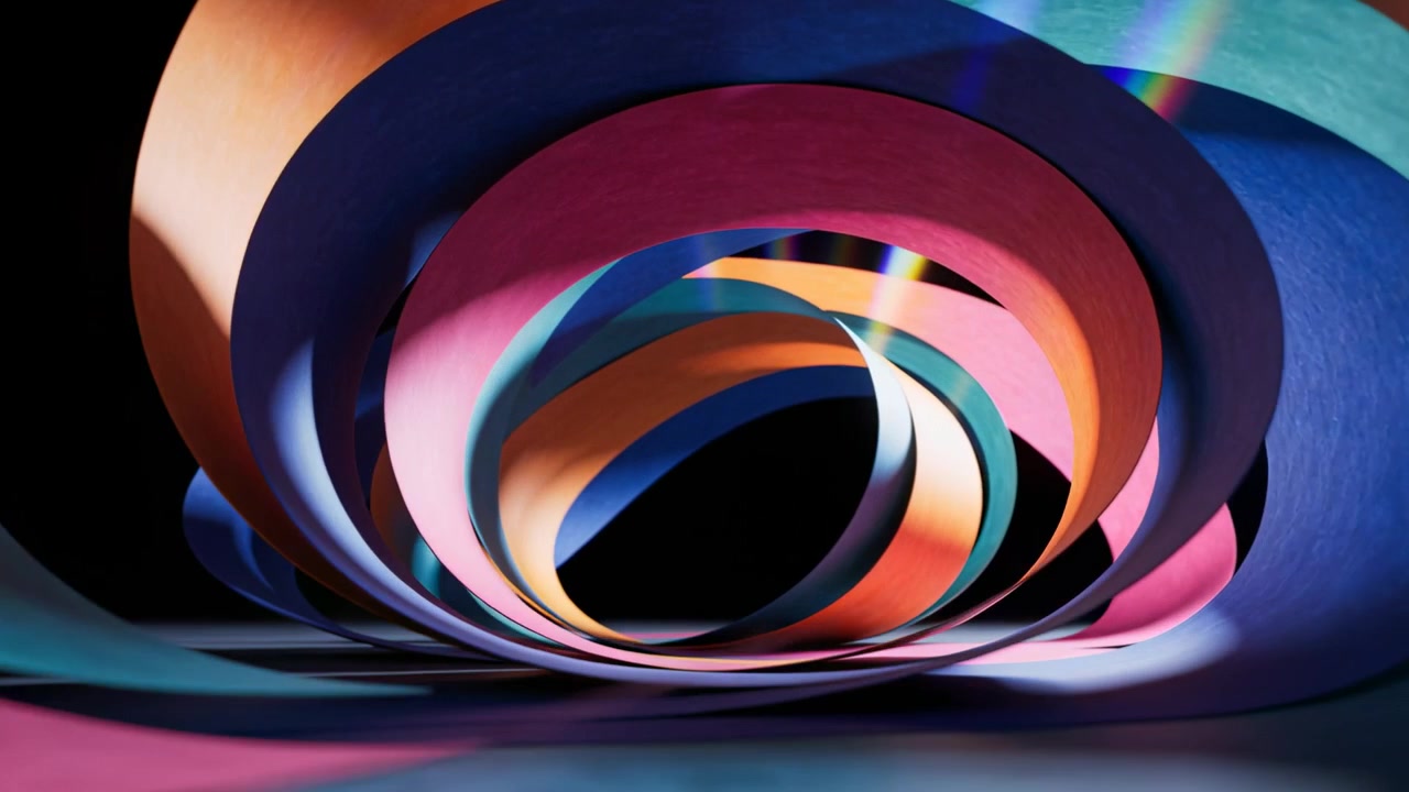 Moving camera revealing layered paper spiral on tabletop, tracking prismatic light, showing depth