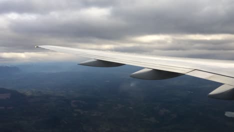 airplane wing over cloudy landscape