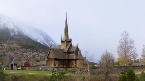 Iglesia-Tradicional-De-Madera-En-Lom-Stavkyrkje-Con-Valla-De-Pared-Empedrada-En-Noruega