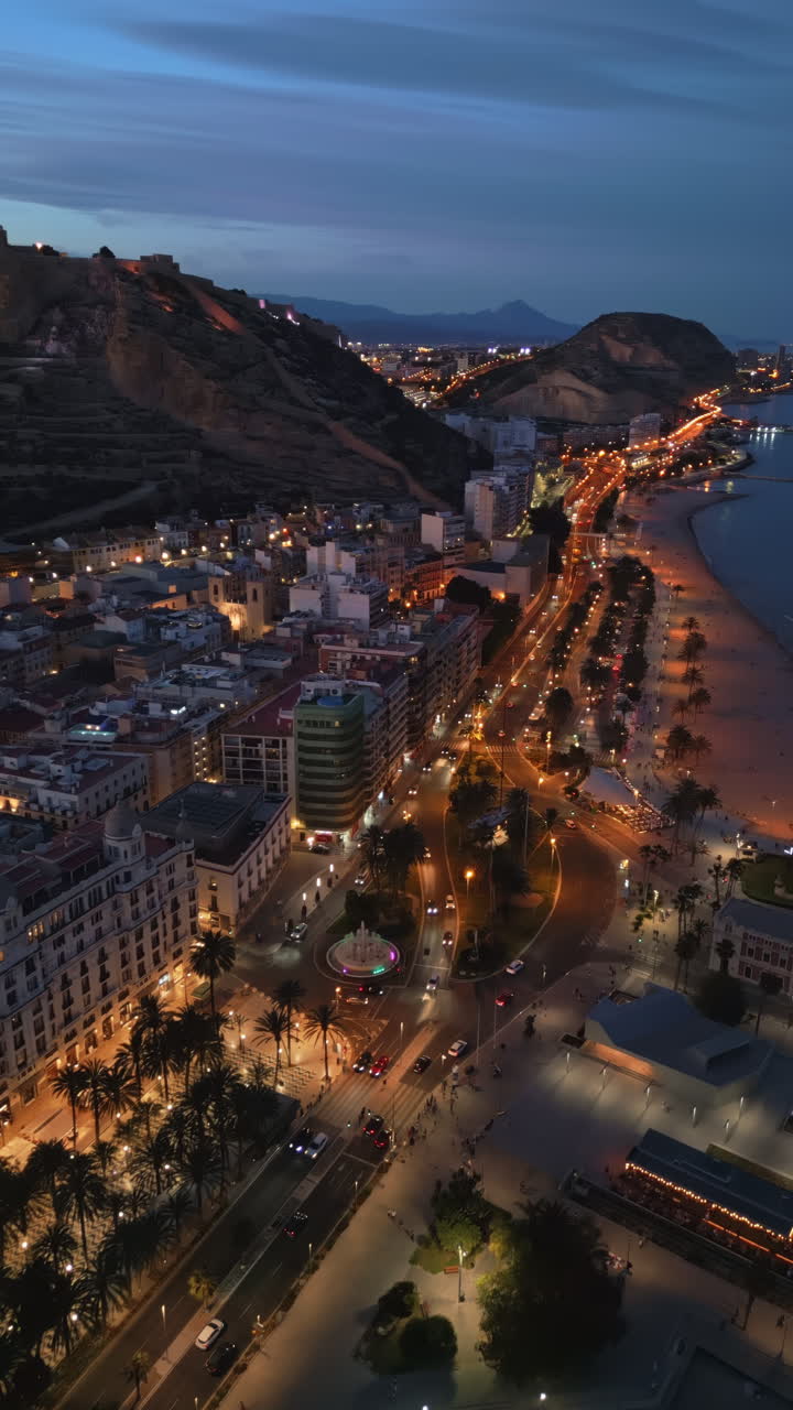 Aerial drone view of the Santa Barbara Castle on the coast of Alicante, Spain at sunset. Vertical