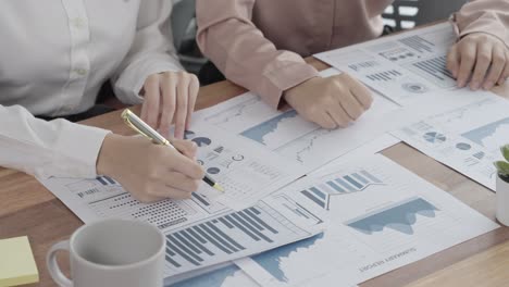 primer plano dos jóvenes mujeres de negocios entusiastas trabajando en la oficina con papel de informe.