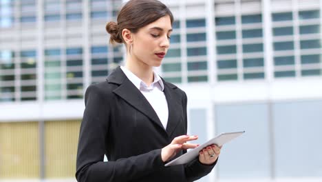 mujer de negocios sonriente usando una tableta digital al aire libre