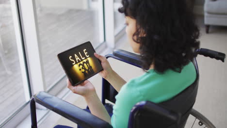 Mujer-Birracial-En-Silla-De-Ruedas-Usando-Tableta,-Compras-En-Línea-Durante-La-Venta,-Cámara-Lenta