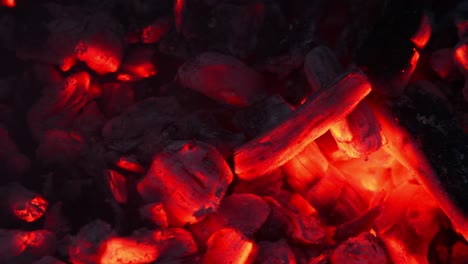 smoldering embers of fire, live coals, burning charcoal in the background texture, closeup, glowing coal. top view.