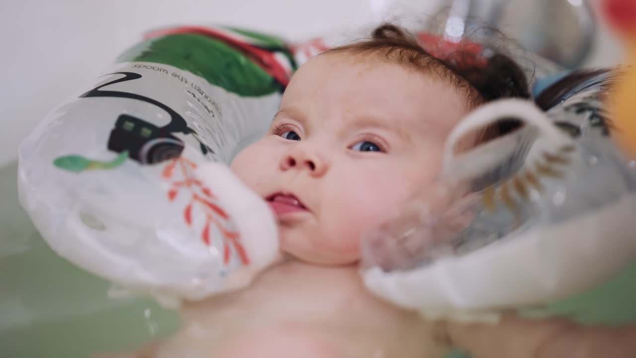 Bebé flotando en la bañera usando un soporte inflable para la hora del baño.