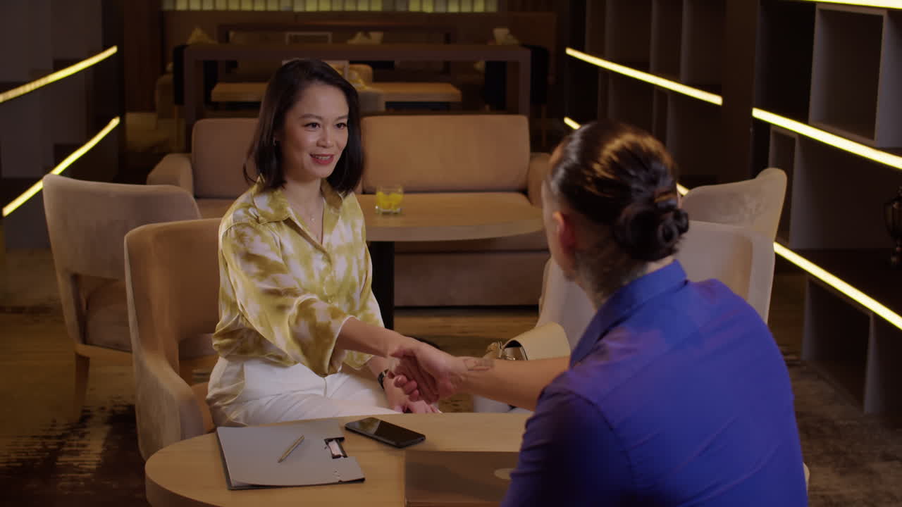 Female Client Meeting with Investor and Shaking Hands