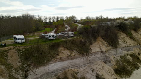 Lift-up-aerial-reveal-of-the-caravan-and-camping-along-the-cliffs-of-Chiapowo-Poland