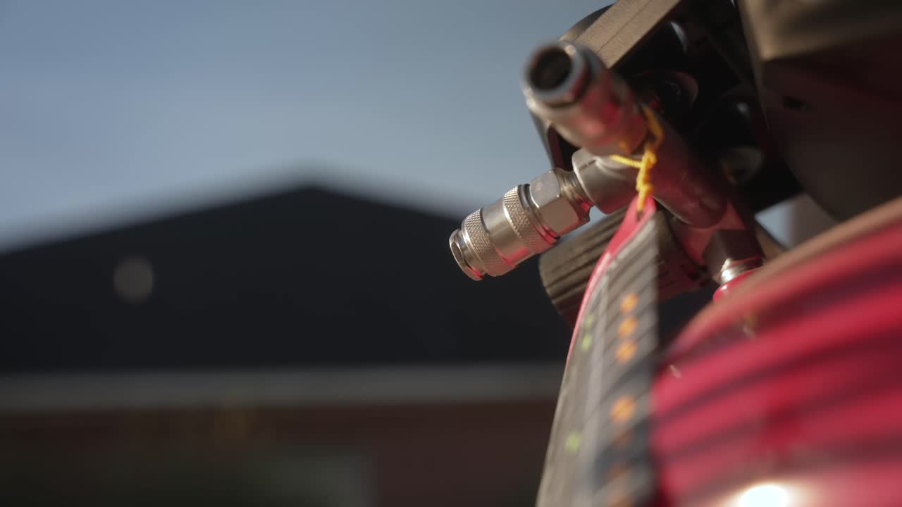 Close-up of connecting an air hose to an air compressor fitting