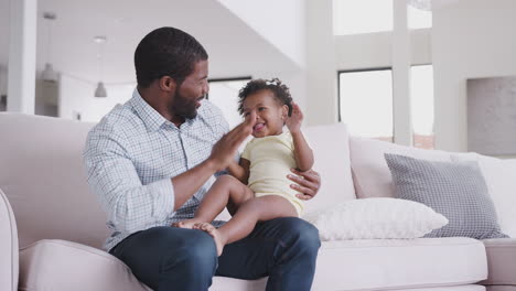 baby daughter gives father high five as they play game at home together