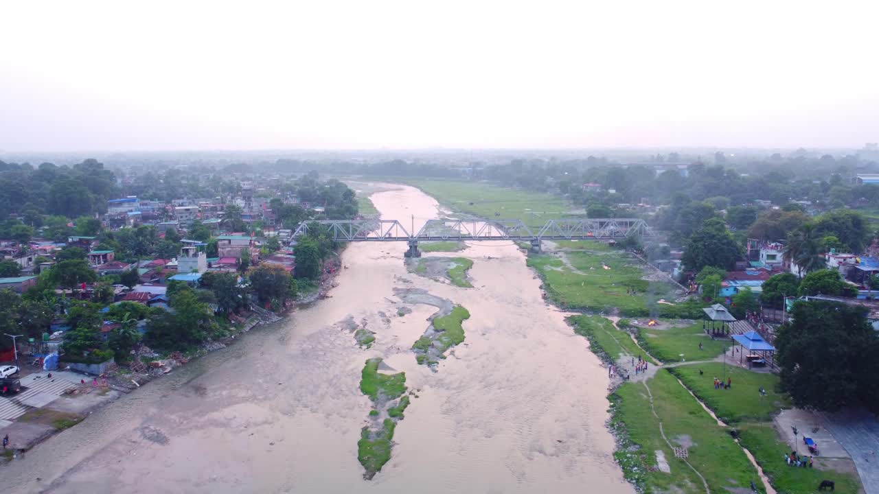 Fiume Mahananda inquinato e sporco con scarichi a cielo aperto di acque reflue che circondano i quartieri baraccopoli, Siliguri, ripresa con drone.