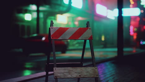 a single barricade stands on a wet, foggy city street at night.