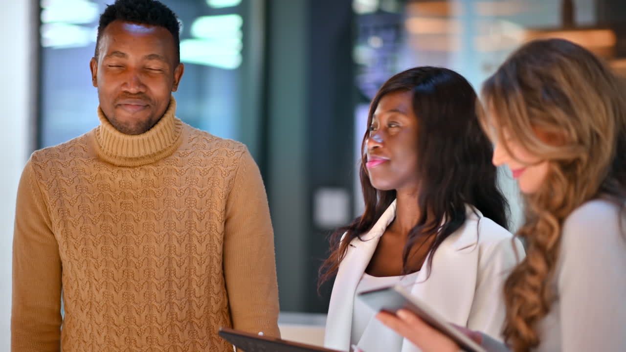 Multiracial group of people in an office discussing business using tablets