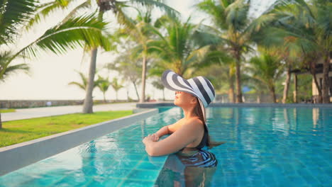 Modelo-Asiático-Refrescándose-En-Una-Piscina-Exótica-En-Pattaya