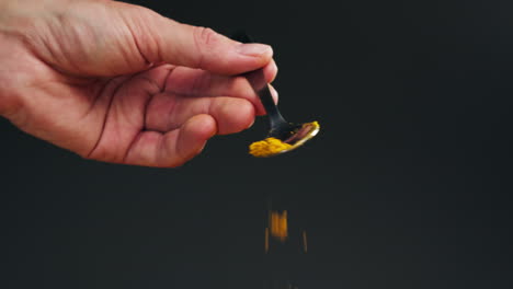 spice turmeric powder on spoon close up. sprinkle turmeric powder. spice for food and drinks. healthy. 4k uhd footage. high quality 4k footage