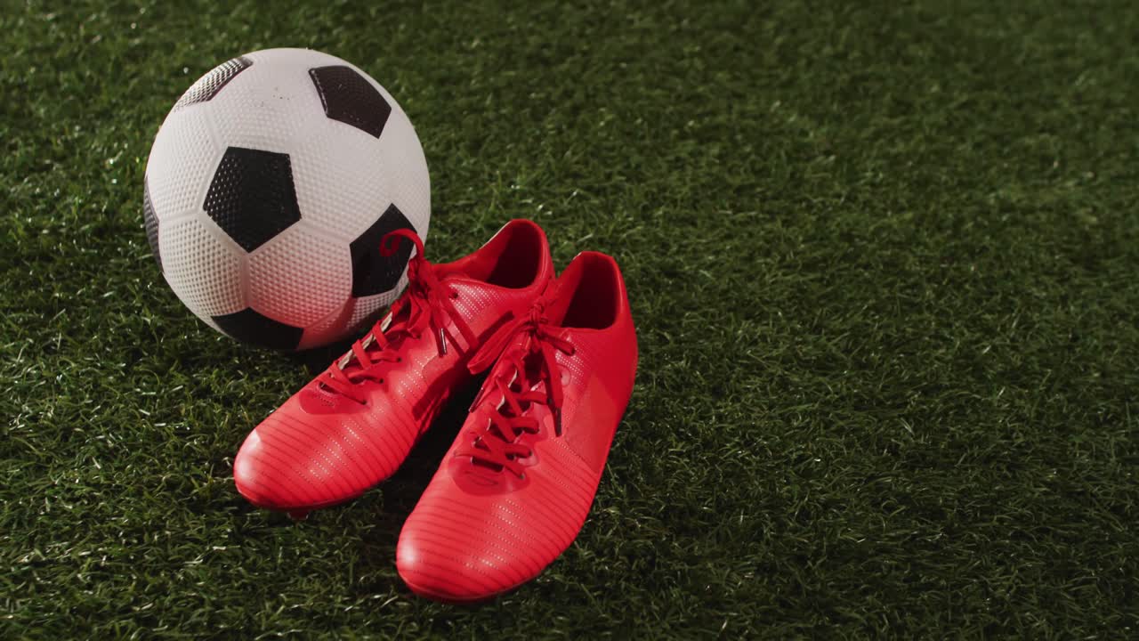 Animazione di un pallone da calcio e scarpe rosse sull'erba con spazio per il testo