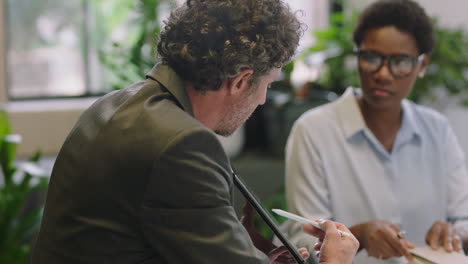 Gente-De-Negocios-Reuniéndose-Con-El-Gerente-De-Proyecto-Empresario-Mostrando-Prototipo-De-Turbina-De-Motor-En-La-Pantalla-De-Una-Tableta-Presentando-Innovación-De-Diseño-Al-Grupo-De-Gestión-En-La-Sala-De-Juntas