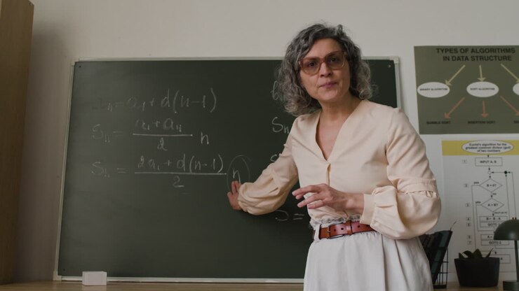 Teacher explaining algorithms on a blackboard