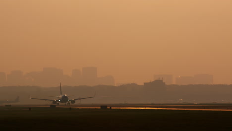 avión despegando o aterrizando al atardecer sobre el horizonte de la ciudad
