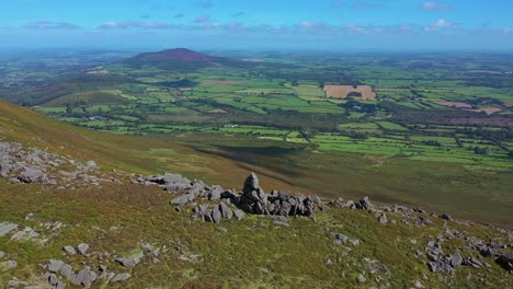 vista de la órbita aérea del afloramiento rocoso, la línea de la cresta y el valle con vistas a la distancia sobre el sur de las tierras de cultivo de irlanda