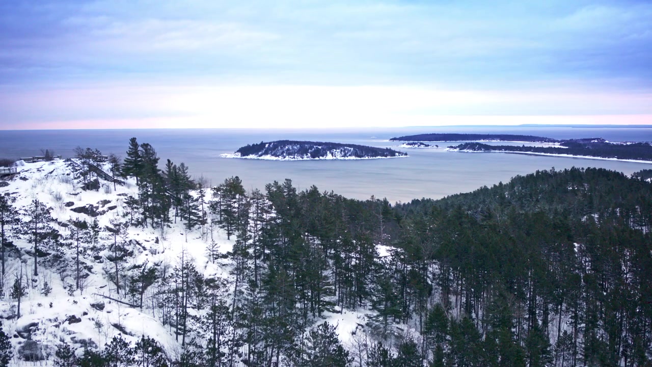 Ilmakuva dronella lumipeitteisestä maaseudusta Pohjois-Michiganissa talvella.