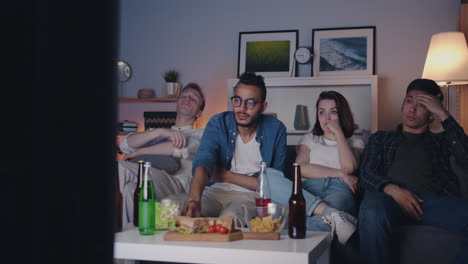 amigos viendo la televisión en casa