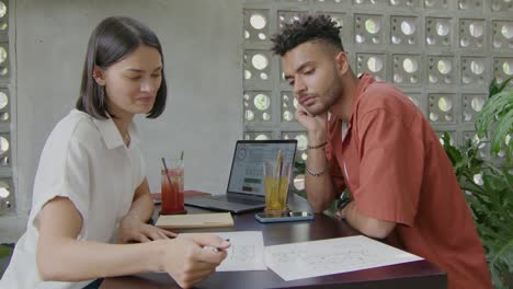 colleagues discussing business plan in coworking cafe