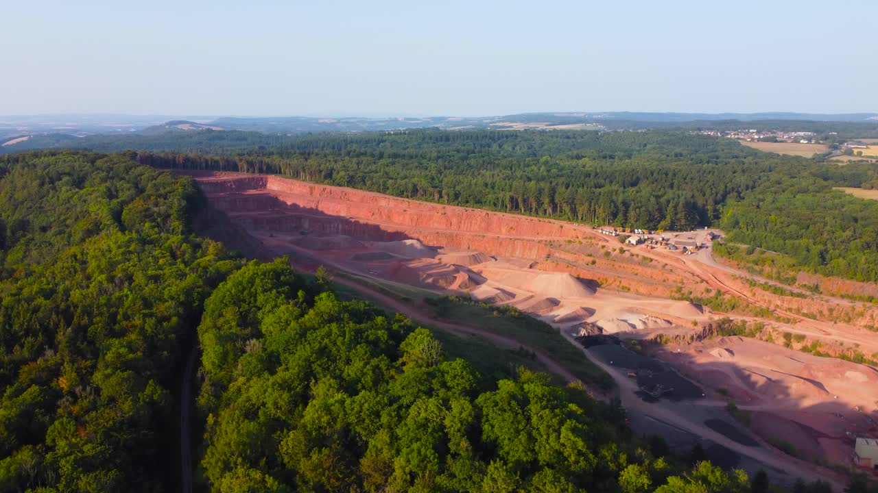 Rising Aerial Over Quarry Excavating Stone Sand Gravel for Buildings Deep in Forest. Heavy Mining Excavating Industry Surrounded by Natural Environment