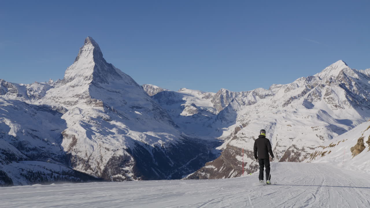 Skiing in Zermatt under the Matterhorn during a blue bird day and perfect slopes. High performance carving on skis.