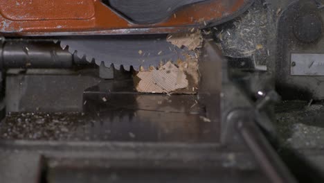 wood chips flying everywhere while a saw stops during cutting a wood block in super slow motion