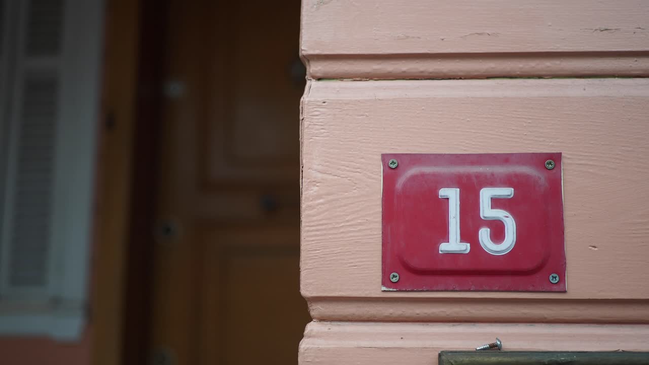 casa número 15 em uma parede rosa