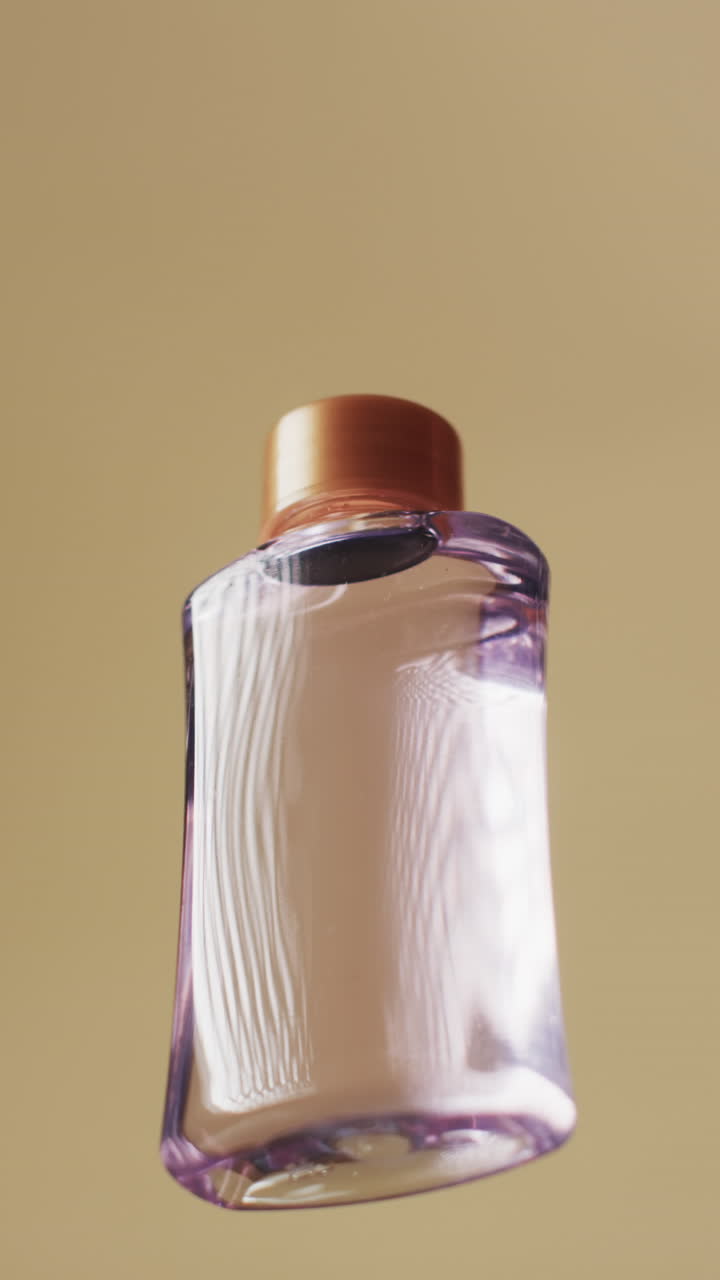 Vertical video of beauty product bottle with copy space on yellow background