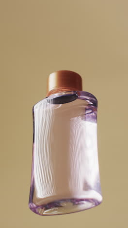 vertical video of beauty product bottle with copy space on yellow background