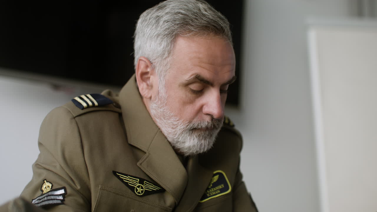 Mature man in uniform writing