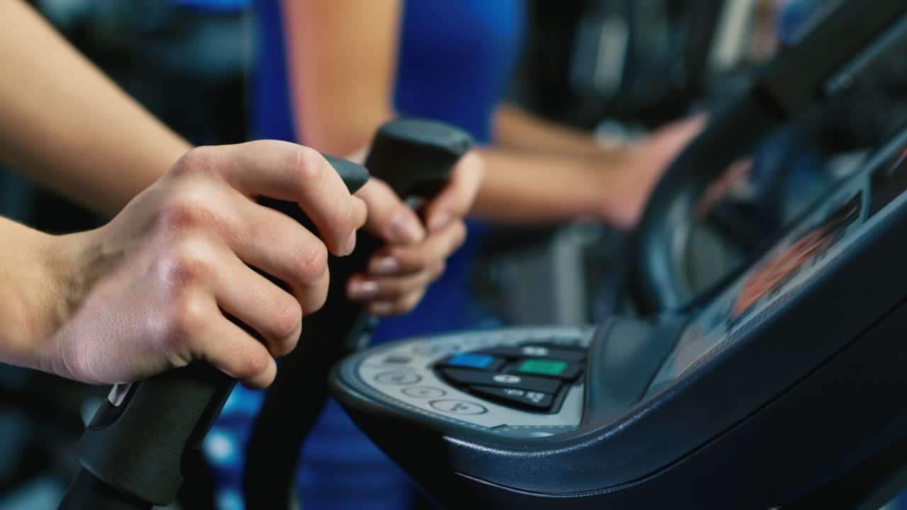 운동선수의 손이 러닝머신을 조정합니다.