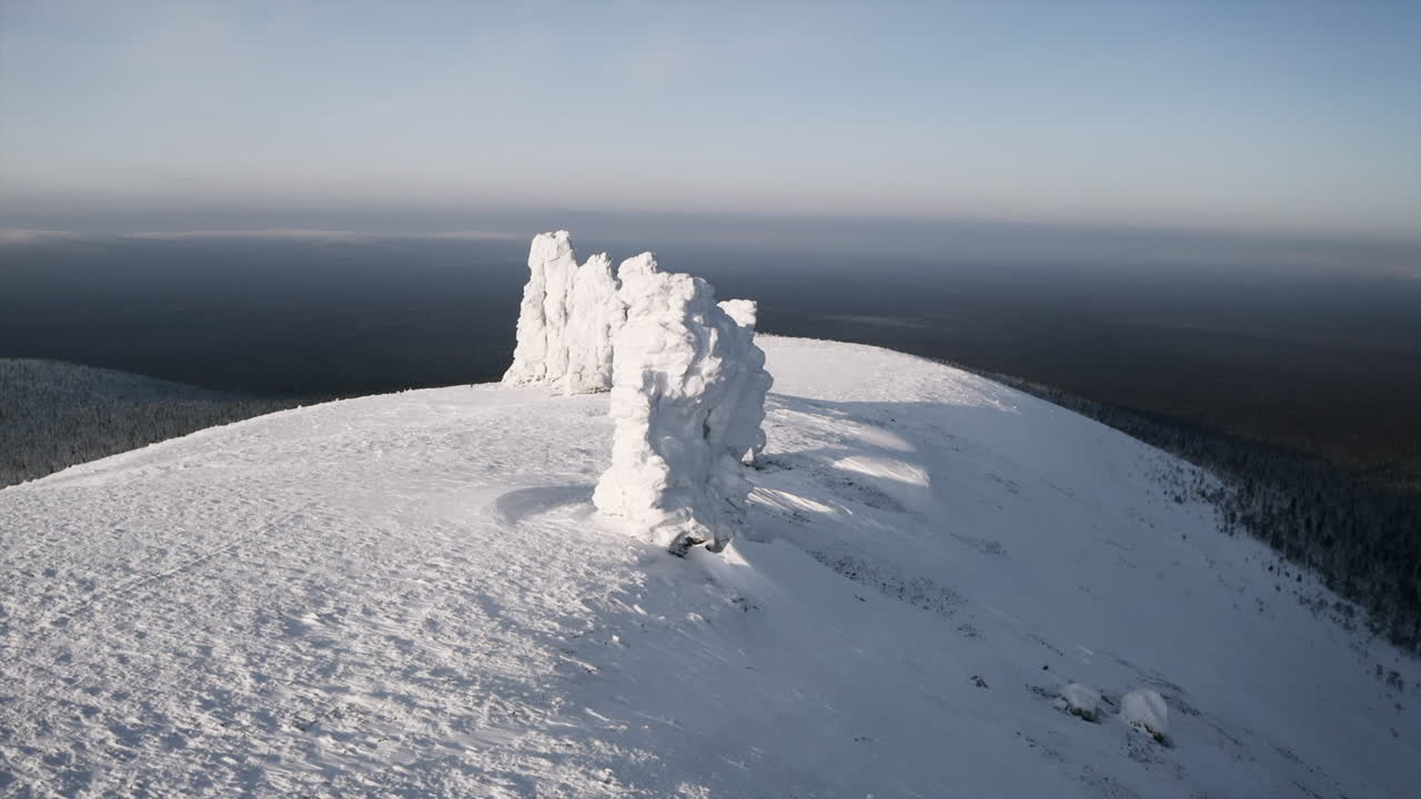 Frosne klippeformationer på en sneklædt bjergtop