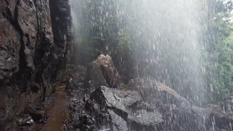 caminando en el camino detrás de la cascada, pov dolly