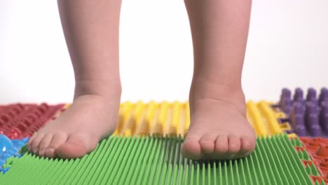 the child does exercises on the orthopedic mat, legs close-up