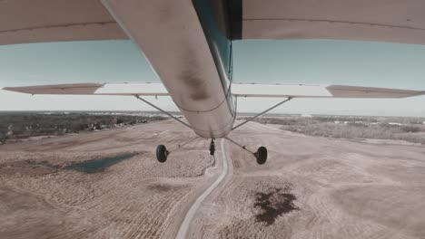 light aircraft cessna 150 gently landing on runway at small airport.