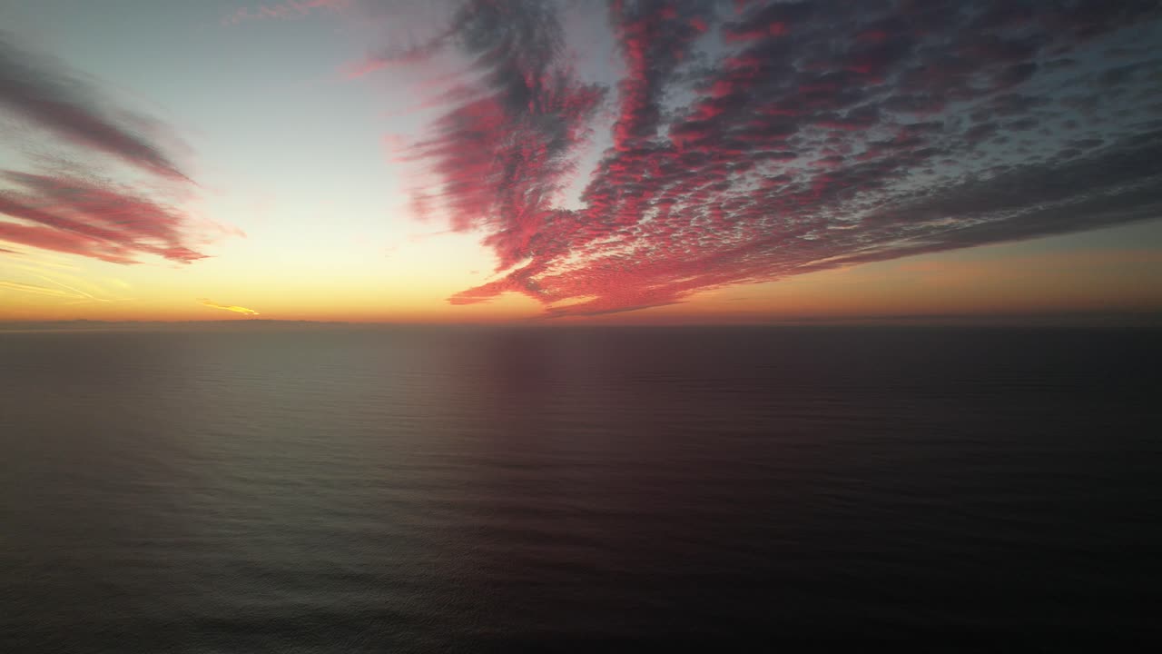 drone frente al océano con una puesta de sol