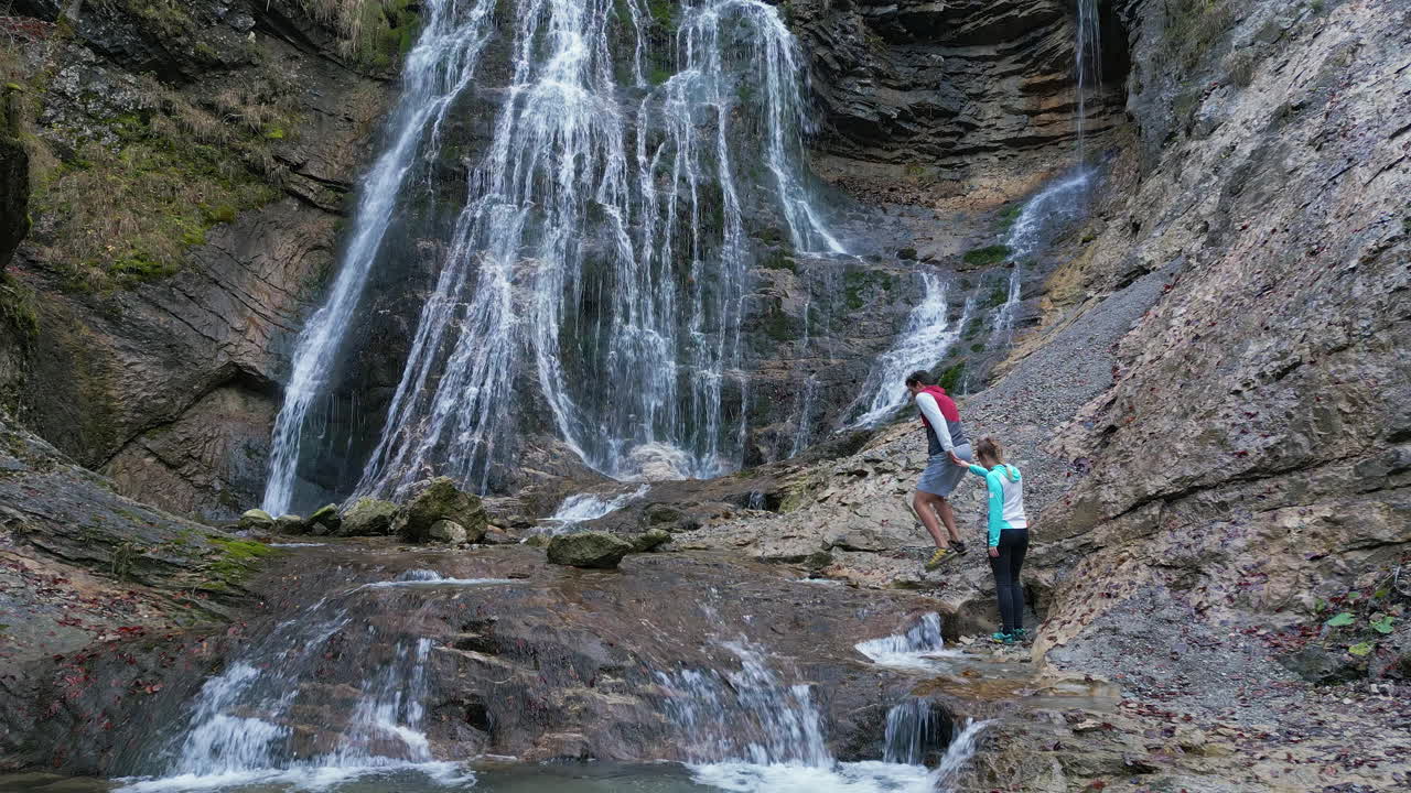 pareja llegando a una cascada y abrazados disfrutar de la belleza de la naturaleza, vista trasera