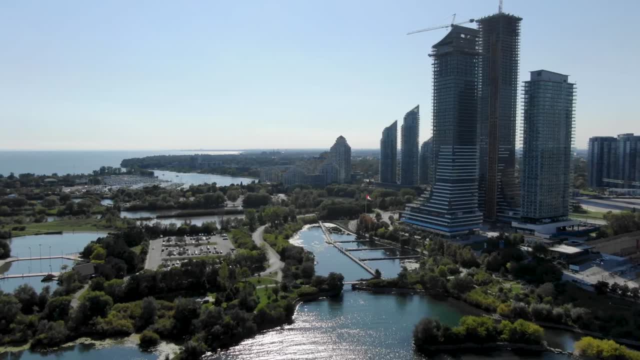 toma aérea volando a lo largo del lago ontario en el verano con barcos y un puerto a la vista