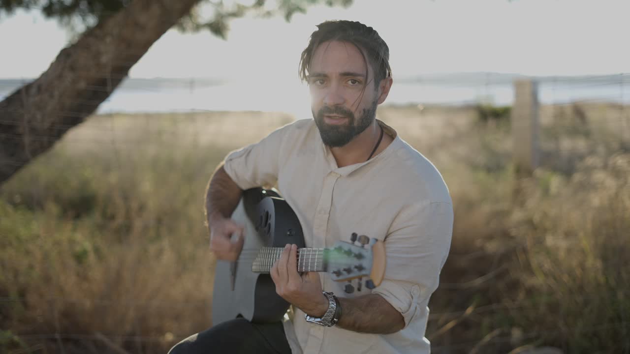 hombre tocando la guitarra acústica al aire libre