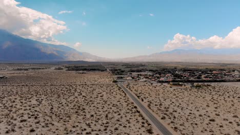 Slow-pull-back-over-innersection-in-small-desert-town-drone