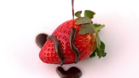 chocolate sauce pouring over strawberry