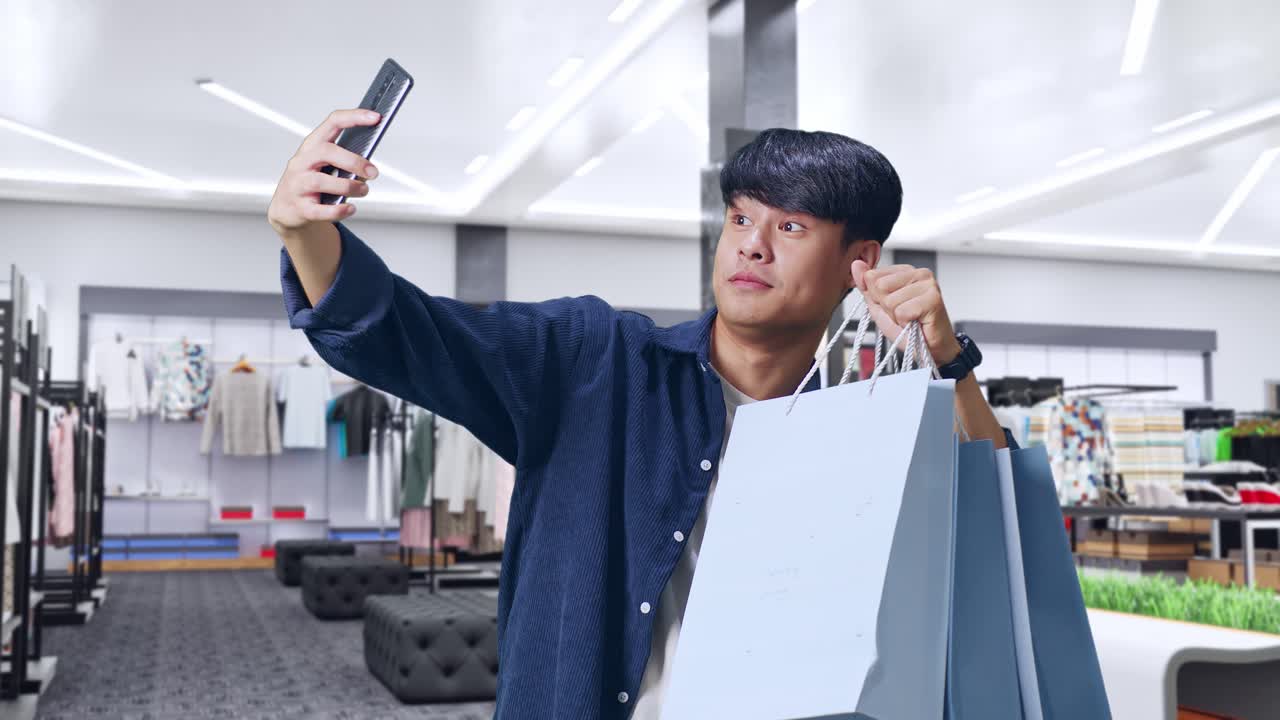 쇼핑 후 옷 가게에서 셀피를 찍는 남자